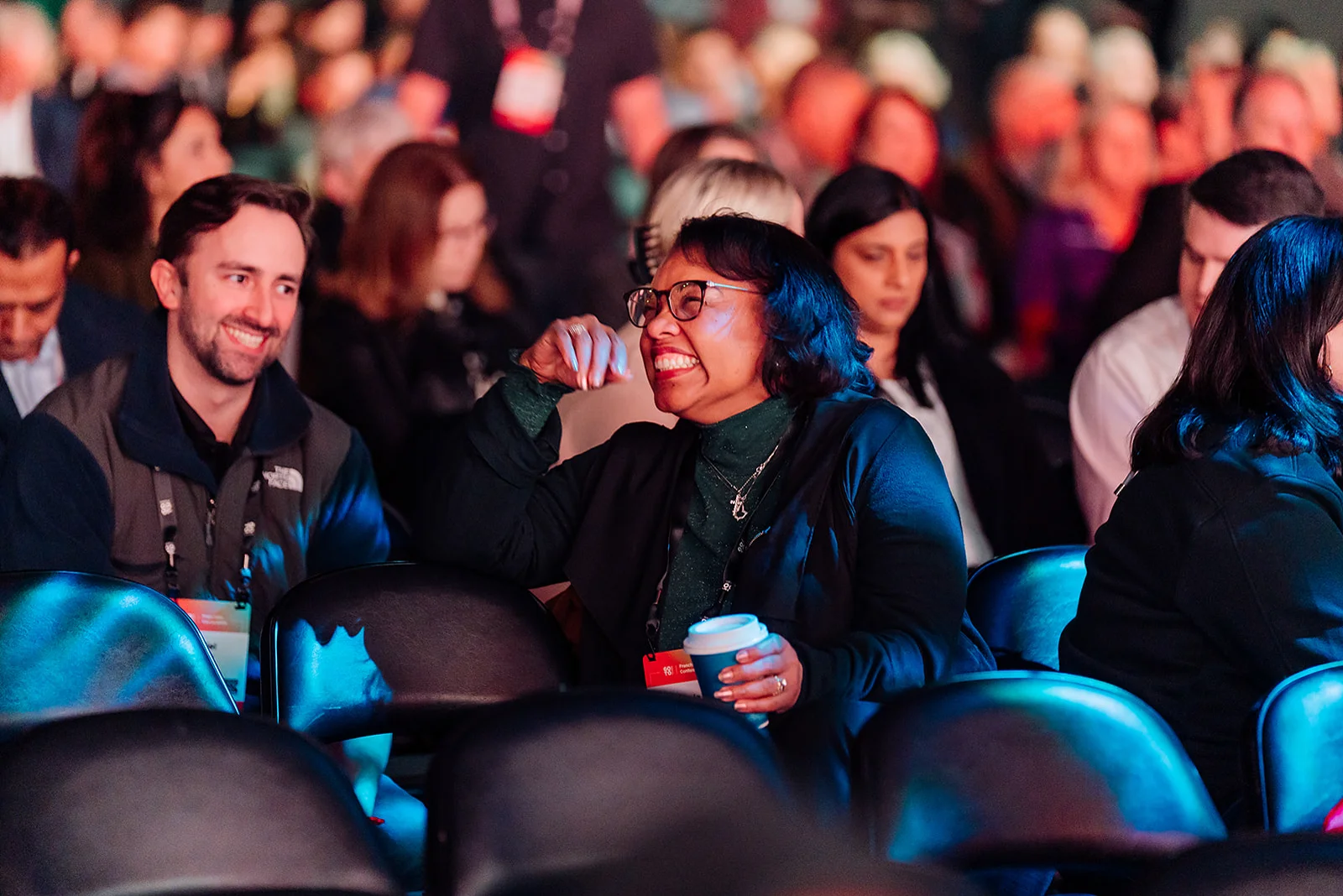 Candid attendee laughing with a colleague in the audience at the Atlanta franchise conference