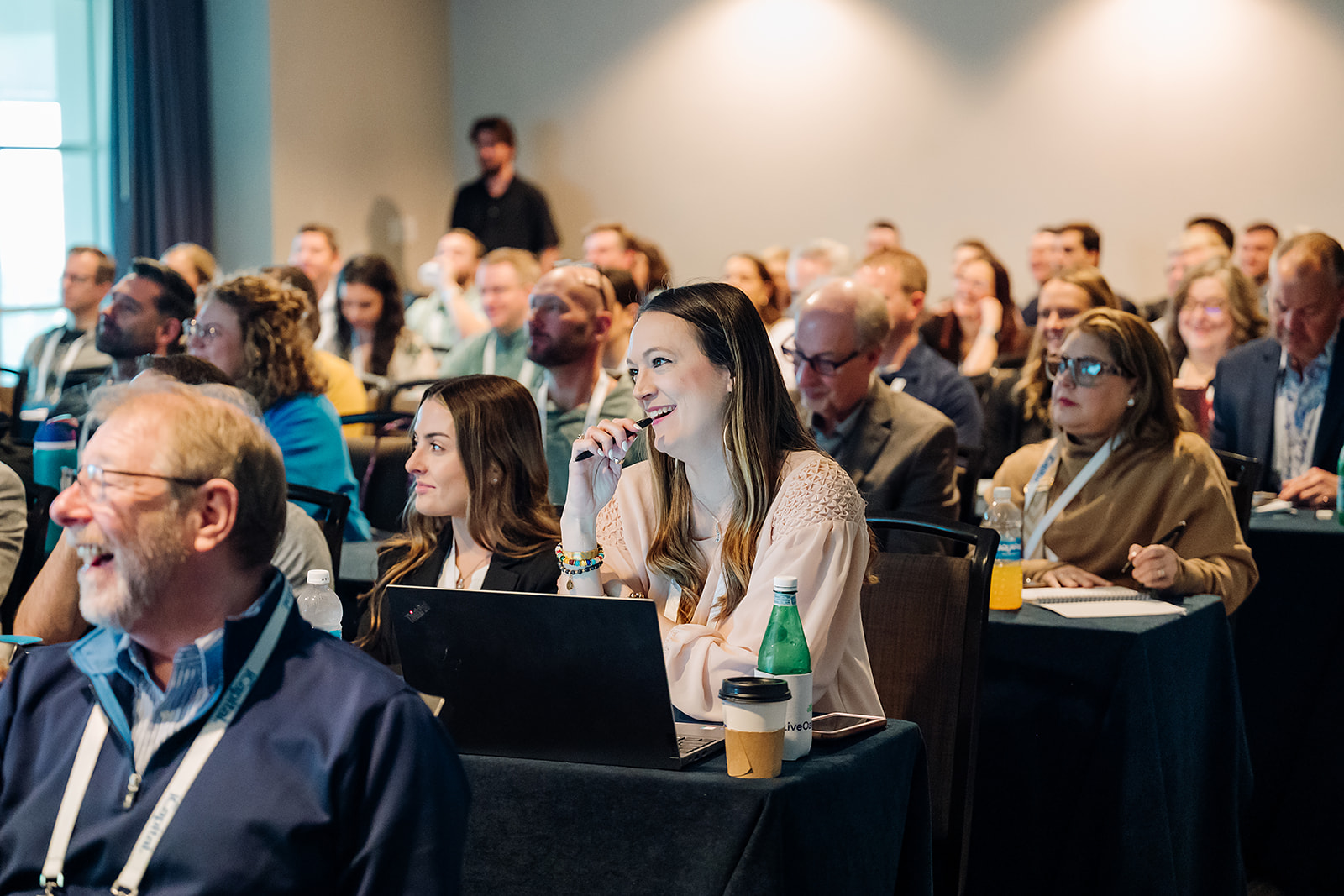 Engaged audience members taking notes during a corporate conference breakout session