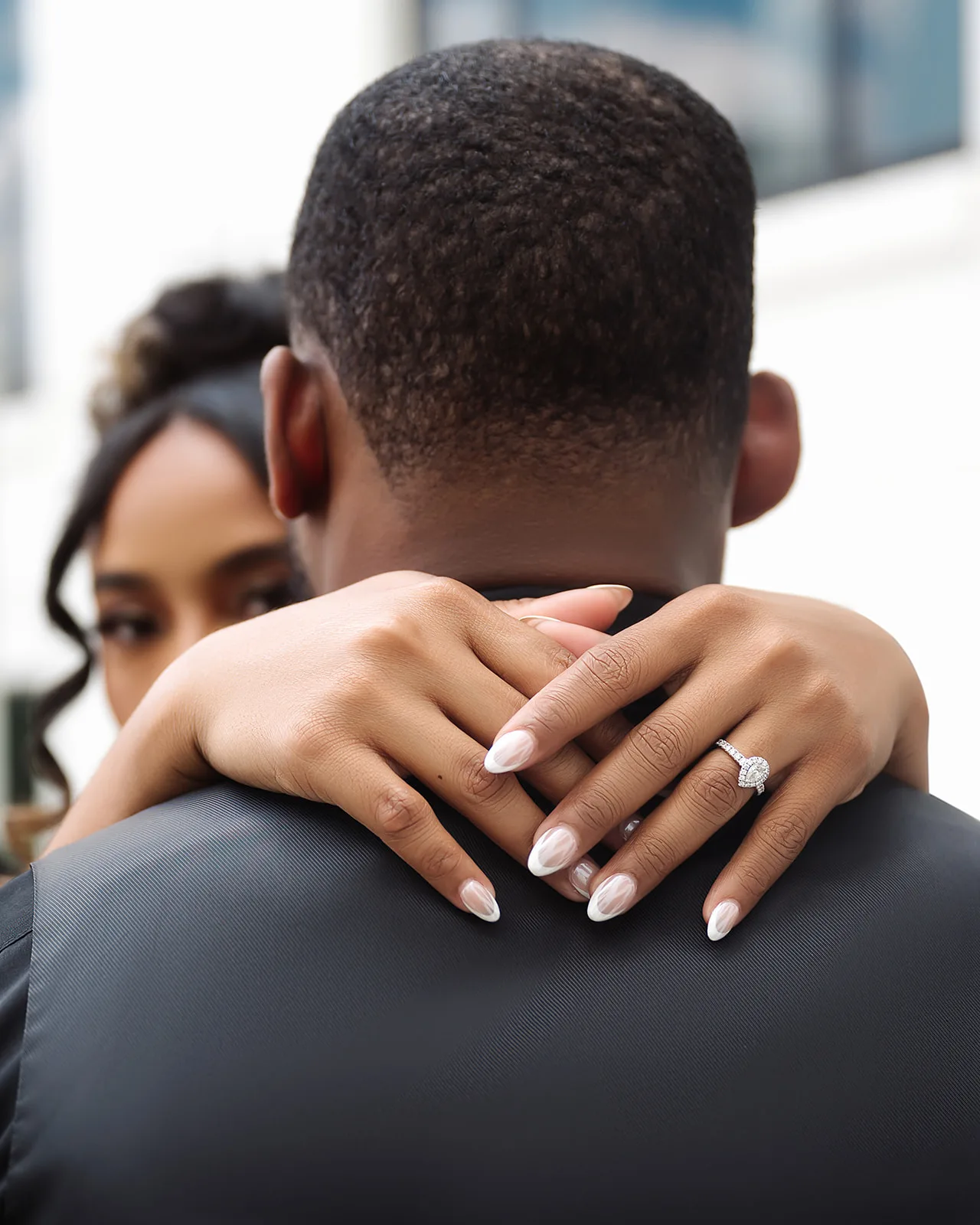 Close-up of engagement ring as couple embraces in Miami