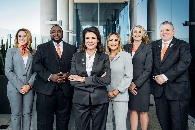 Outdoor group headshot of a leadership team in coordinated business attire