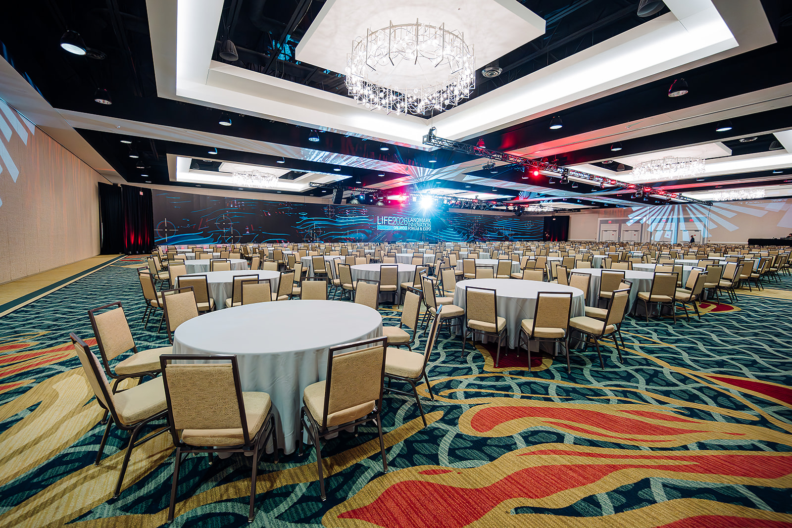 LIFE 2026 Landmark Innovation Forum & Expo ballroom set with round tables and stage in Orlando
