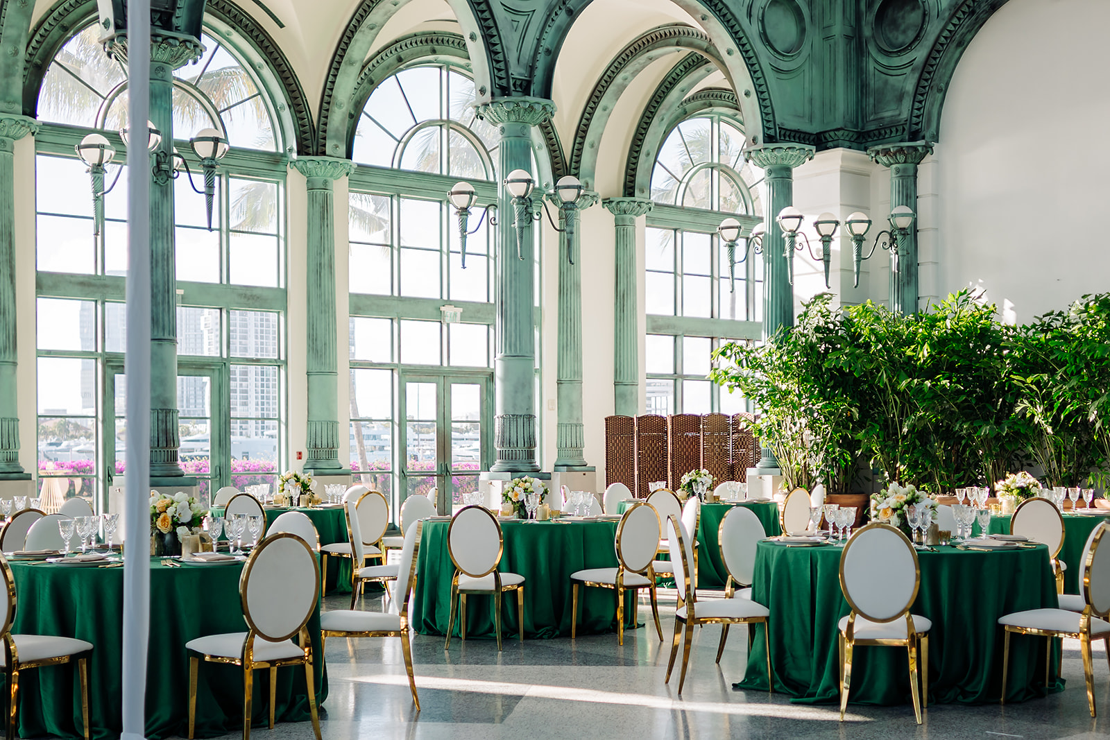 Corporate ballroom event at Flagler Station Miami with arched windows and emerald tables
