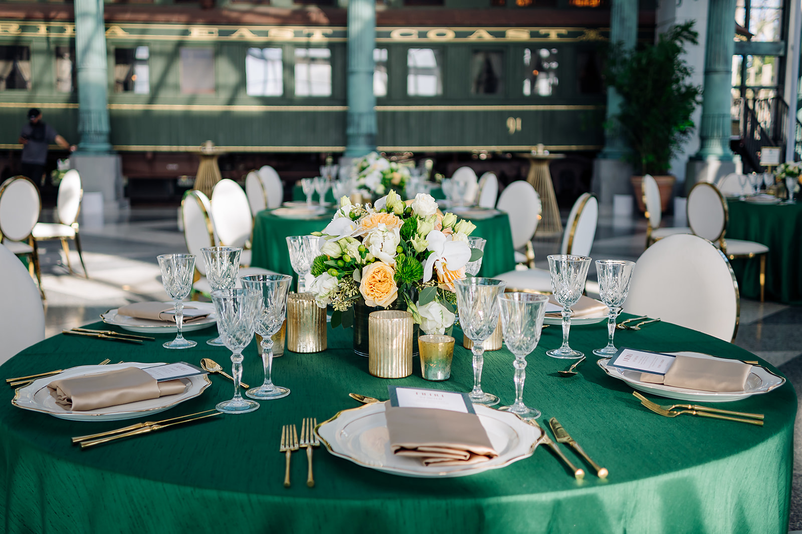 Corporate gala tablescape at Flagler Station Miami with emerald linens and gold accents