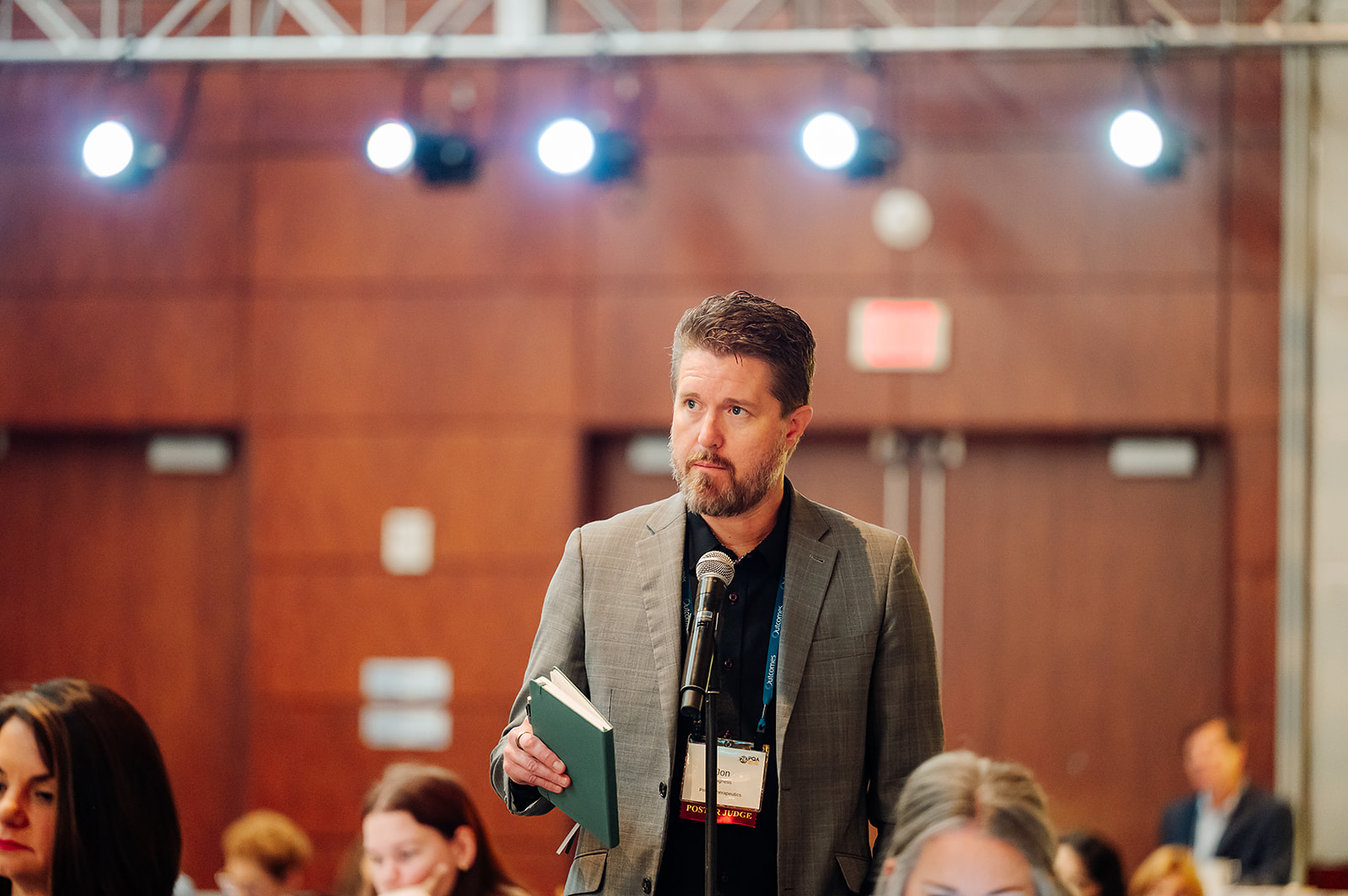 Attendee at PQA Annual Conference speaking at microphone in Baltimore