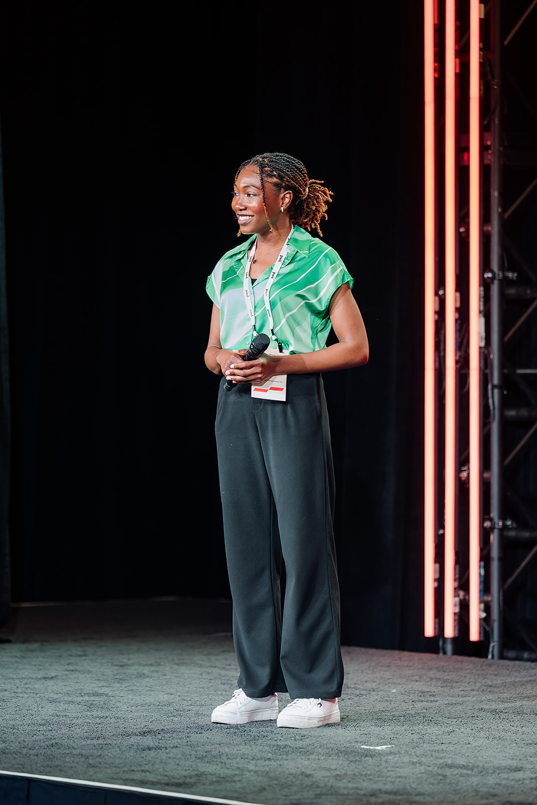PwC WIN conference speaker on stage with red LED lighting