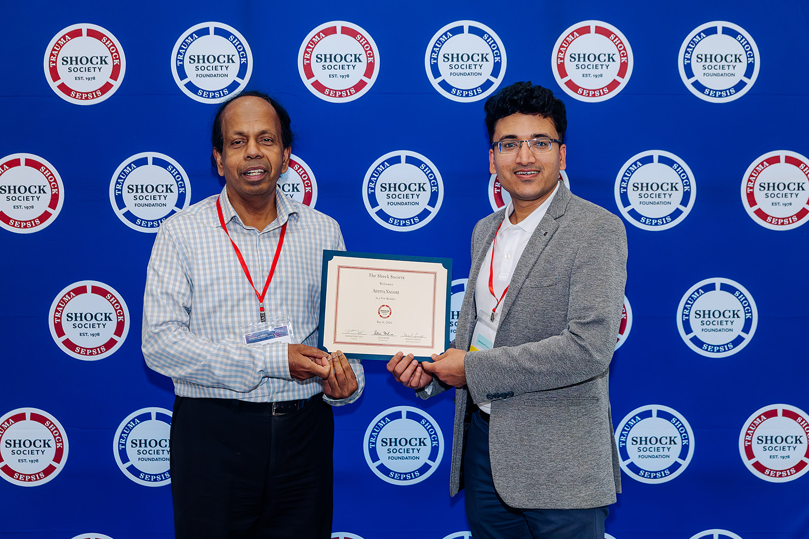 Shock Society new member recognition with certificate on step and repeat backdrop in Las Vegas