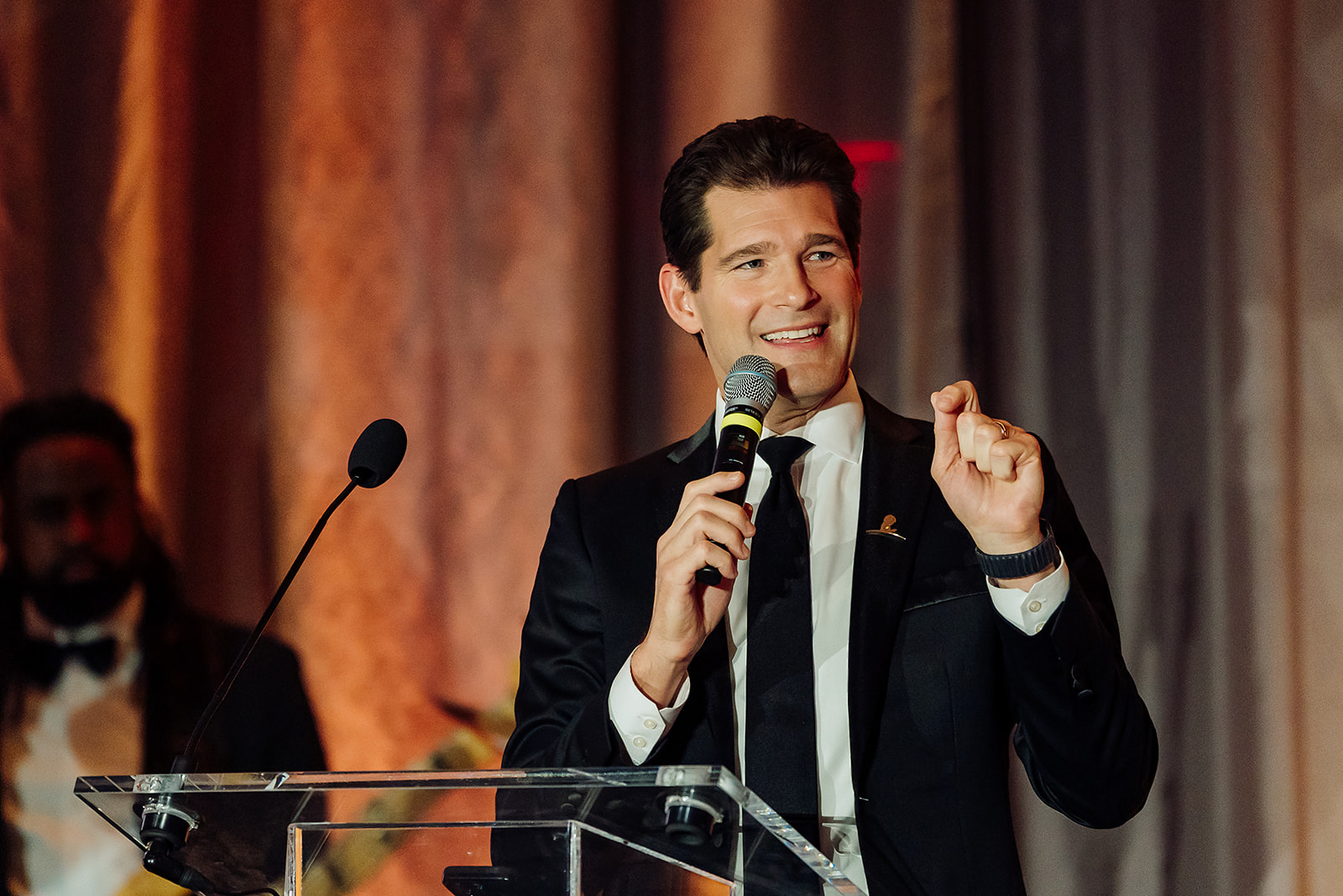 Keynote speaker in black tuxedo speaking at the St. Jude gala