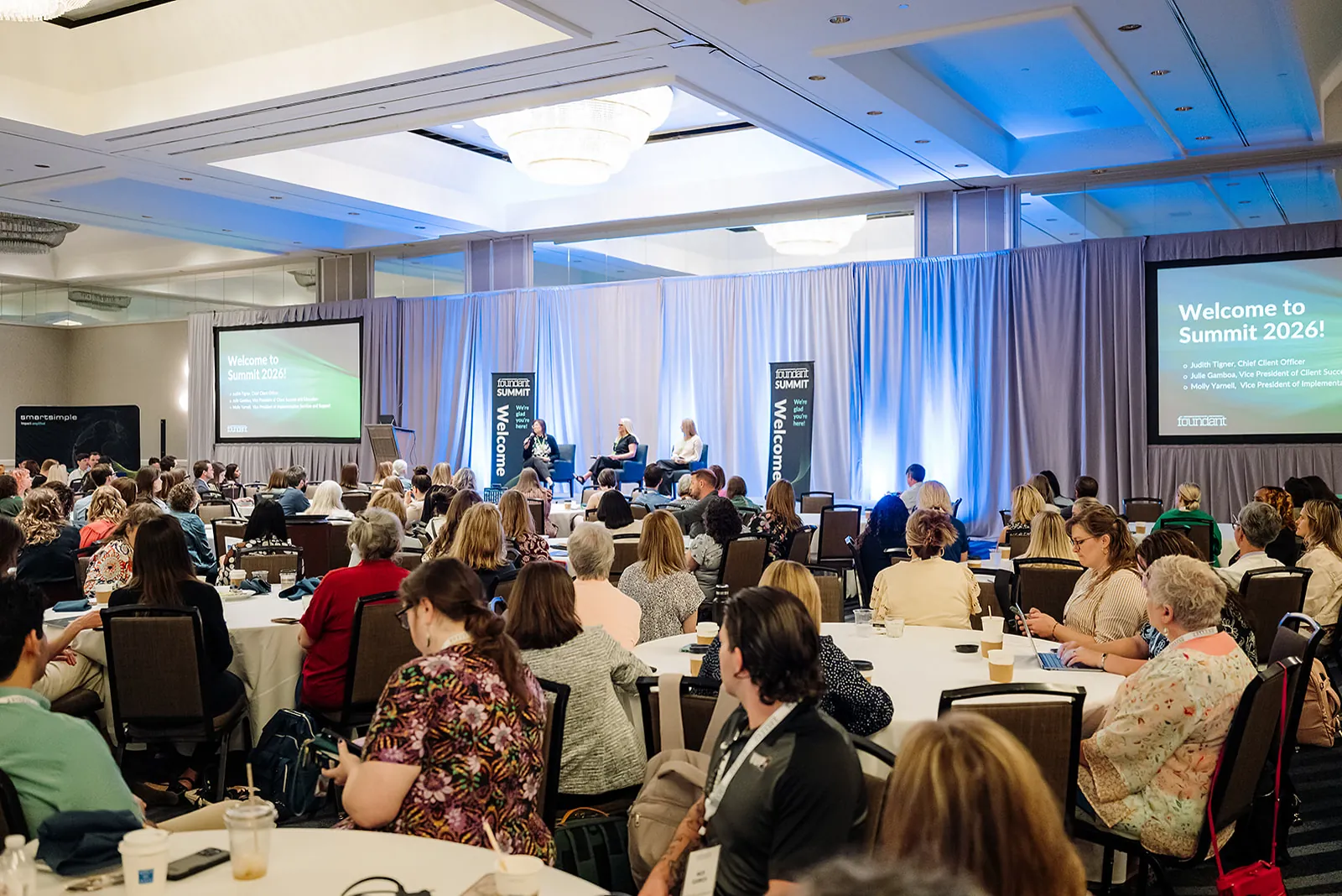 Wide view of the Foundant Summit 2026 general session ballroom with attendees and dual stage screens in Tampa