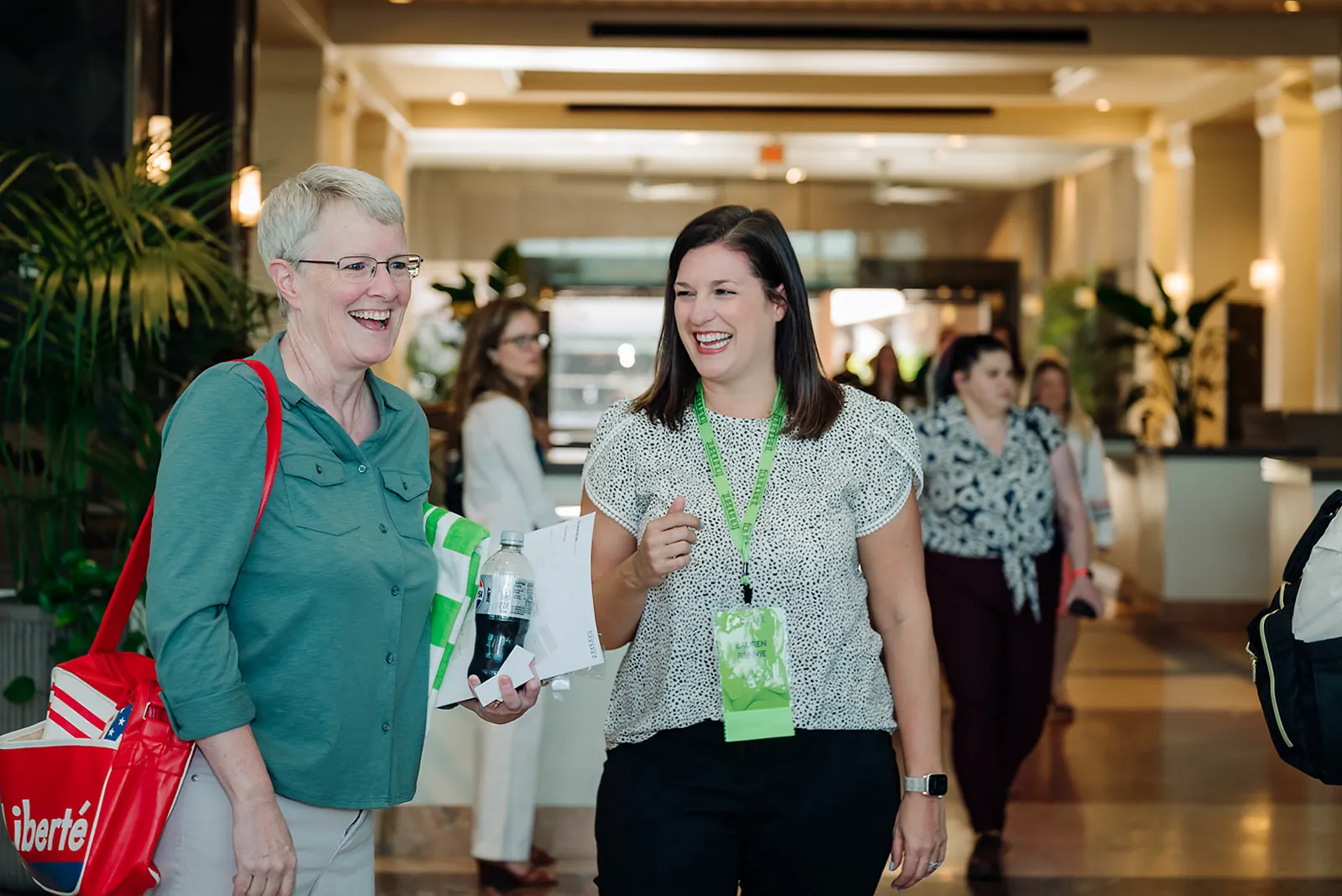 Two Foundant Summit attendees laughing together in the hotel lobby during a networking break in Tampa