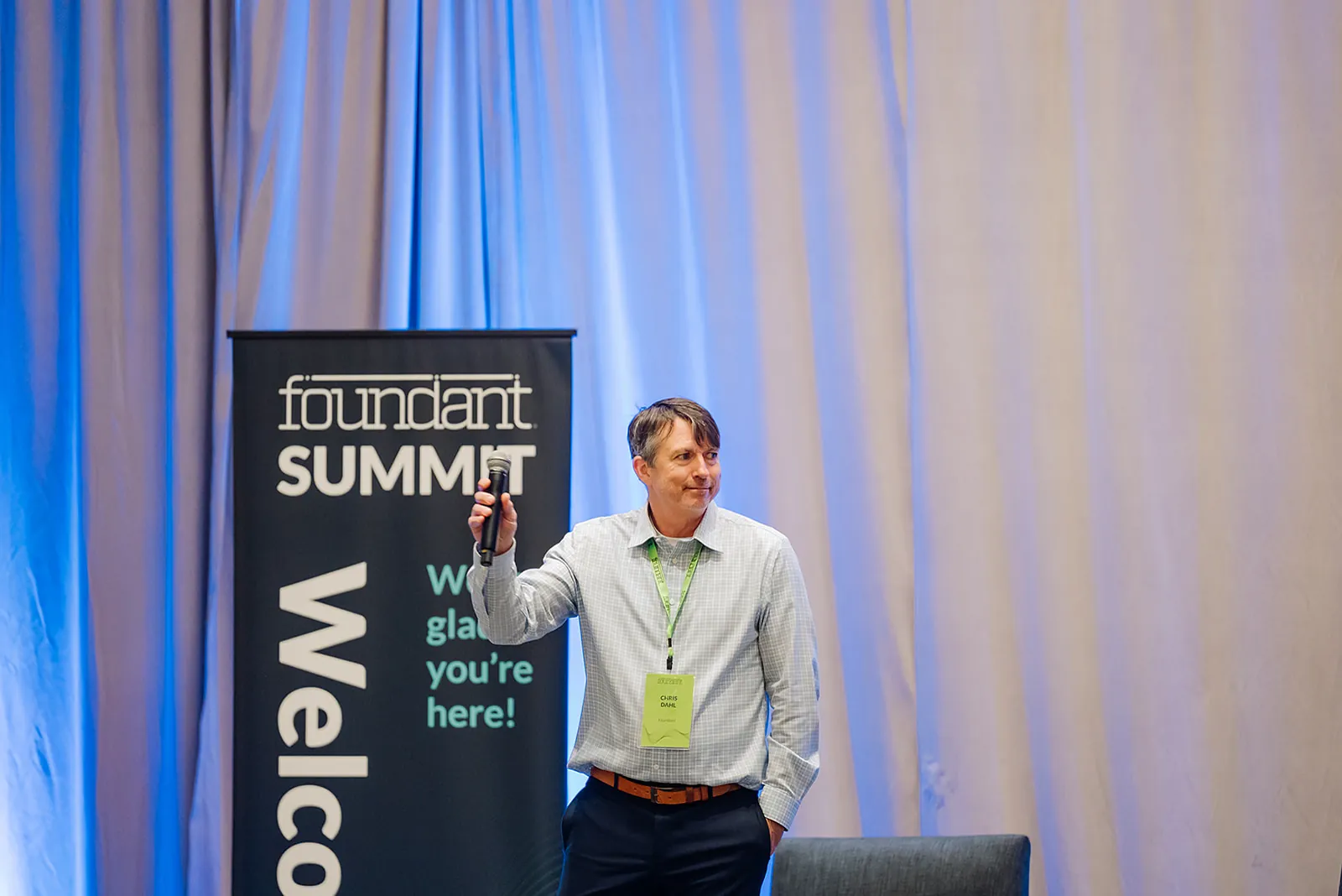 Foundant Summit keynote speaker on stage next to the Welcome banner in Tampa