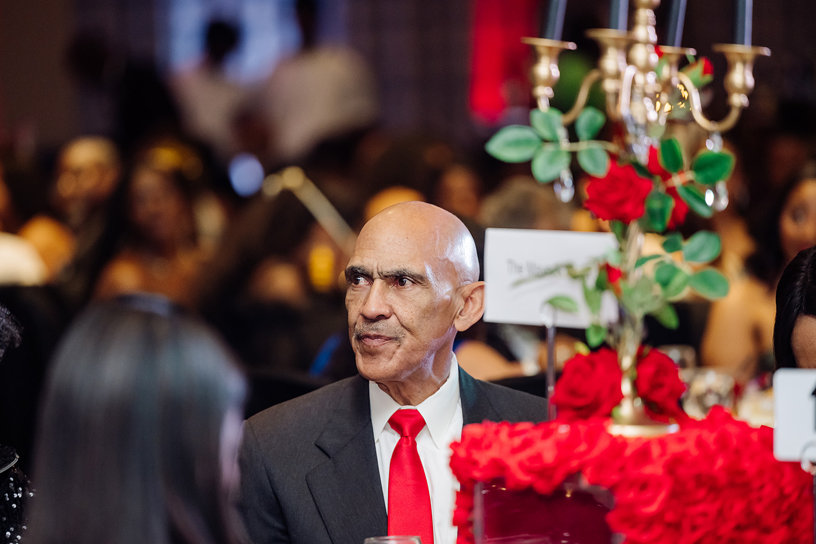 Candid portrait of Tony Dungy at corporate gala dinner with floral centerpieces