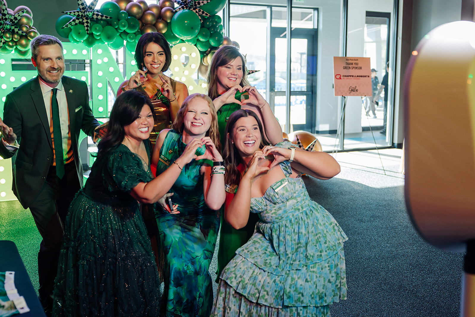 Attendees posing in the photo booth at the USF Green and Gold Alumni Gala
