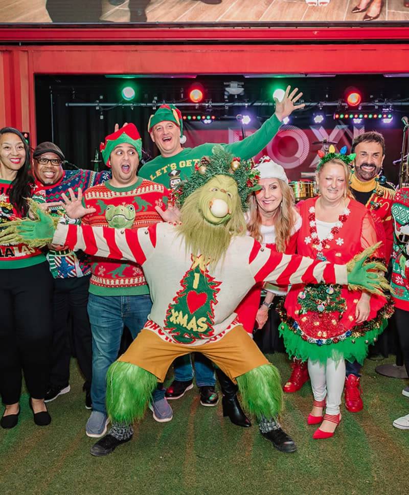 Team in ugly holiday sweaters celebrating at an Orlando corporate holiday party