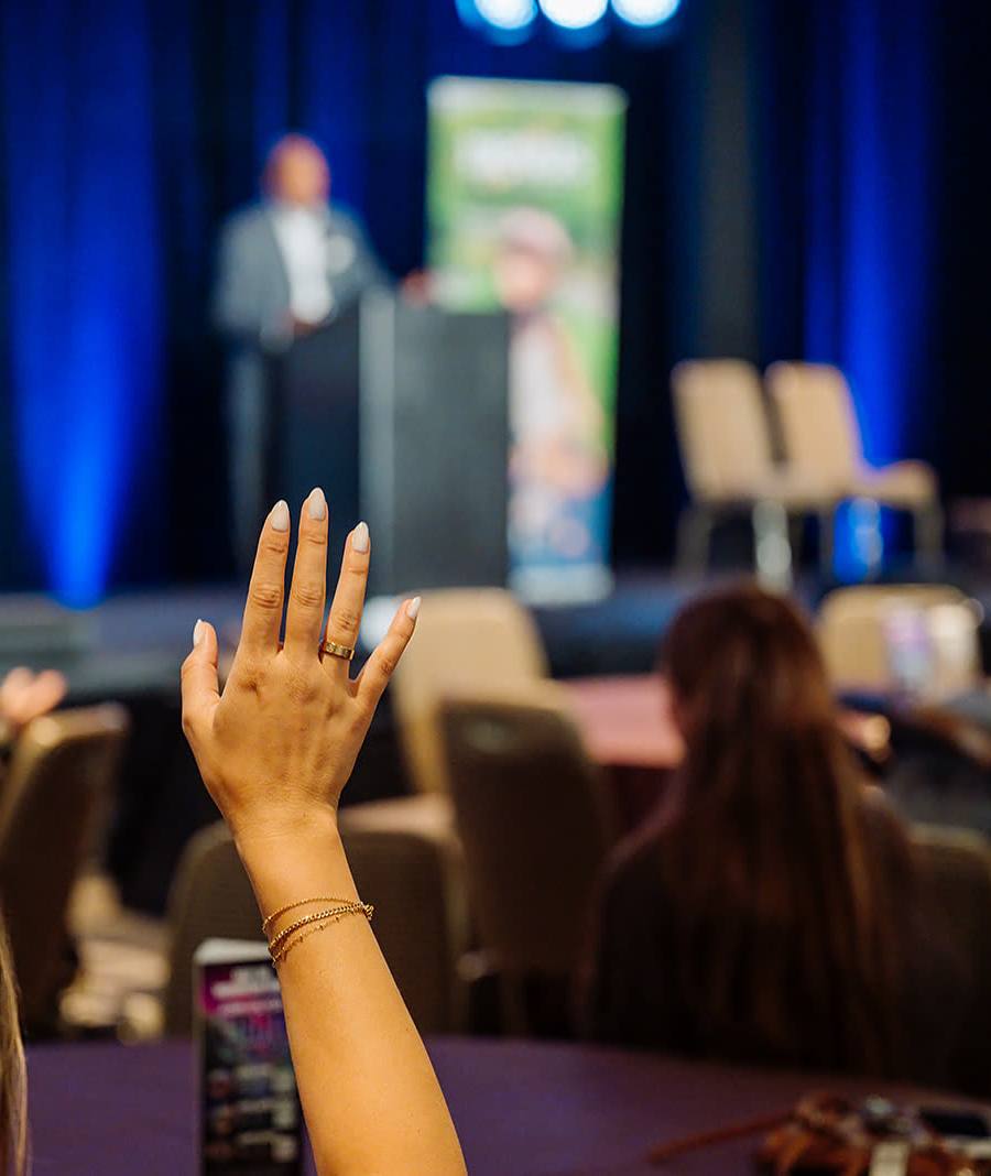 Attendee raising a hand to ask a question during a keynote Q and A