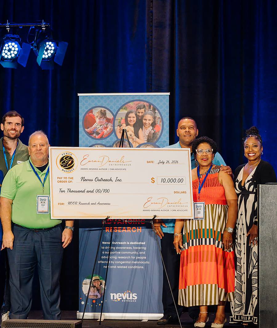 Keynote stage moment with a group presenting an oversized ceremonial donation check