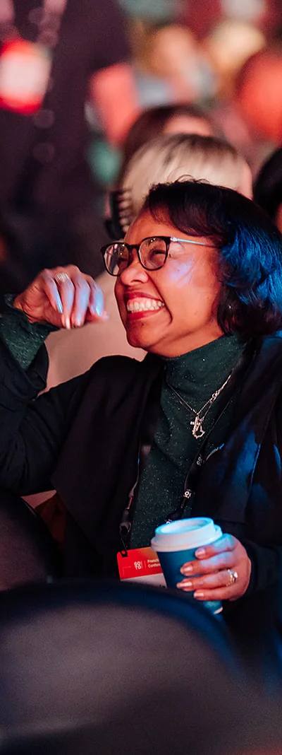 Candid attendee laughing with a colleague in the audience at the Atlanta franchise conference