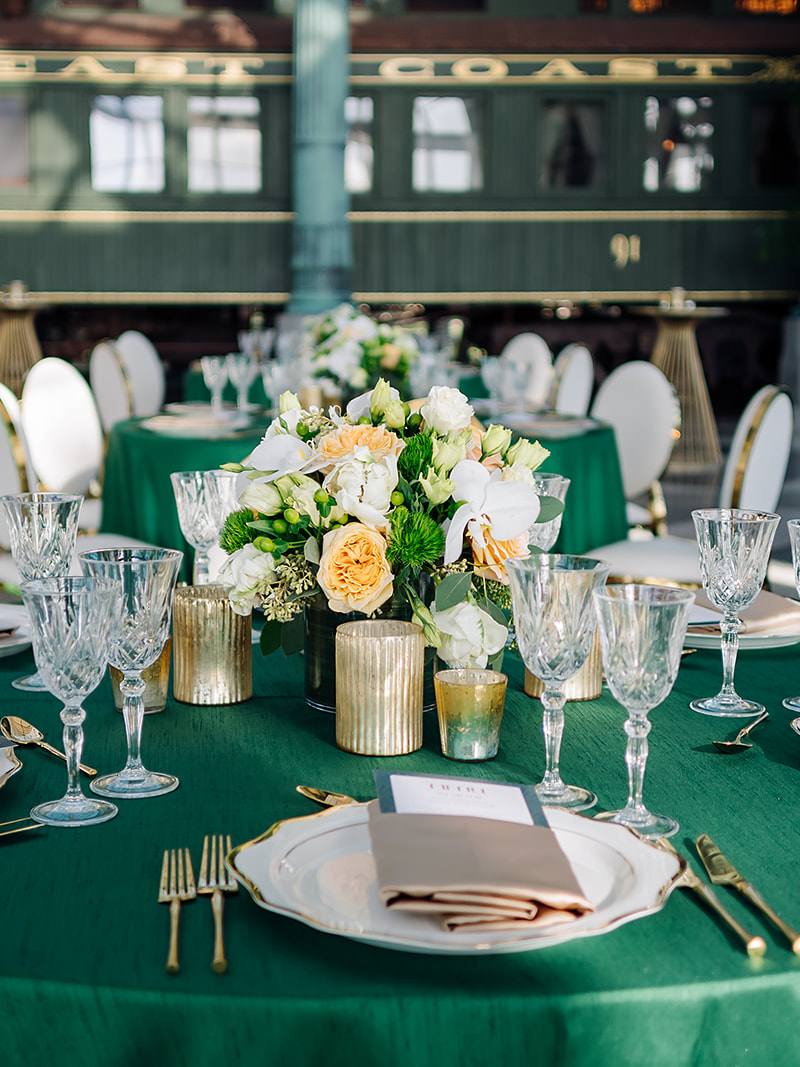 Corporate gala tablescape at Flagler Station Miami with emerald linens and gold accents