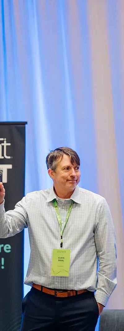 Foundant Summit keynote speaker on stage next to the Welcome banner in Tampa